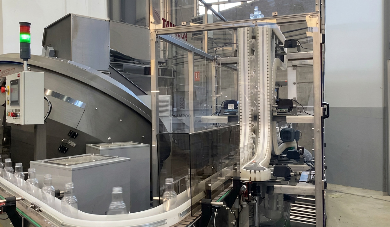 POSIMAT gravity bottle unscrambler integrated into an automated filling line, ensuring reliable bottle feeding and high production efficiency.