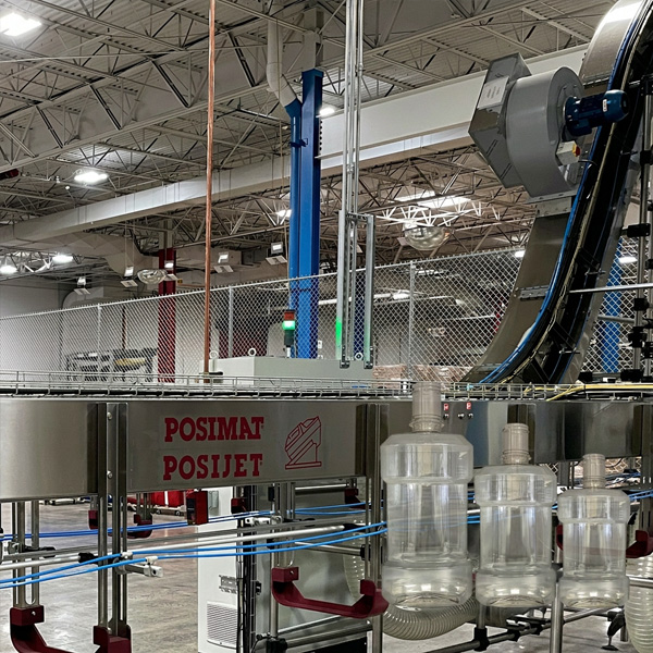 POSIMAT POSIJET air conveyor system transporting PET bottles in a high-speed mouthwash bottling plant, improving efficiency and reducing production bottlenecks.