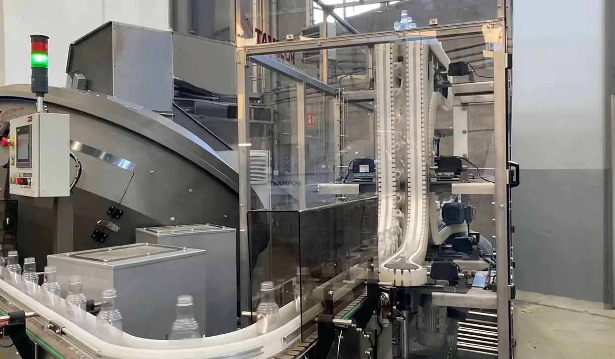 POSIMAT gravity bottle unscrambler integrated into an automated filling line, ensuring reliable bottle feeding and high production efficiency.
