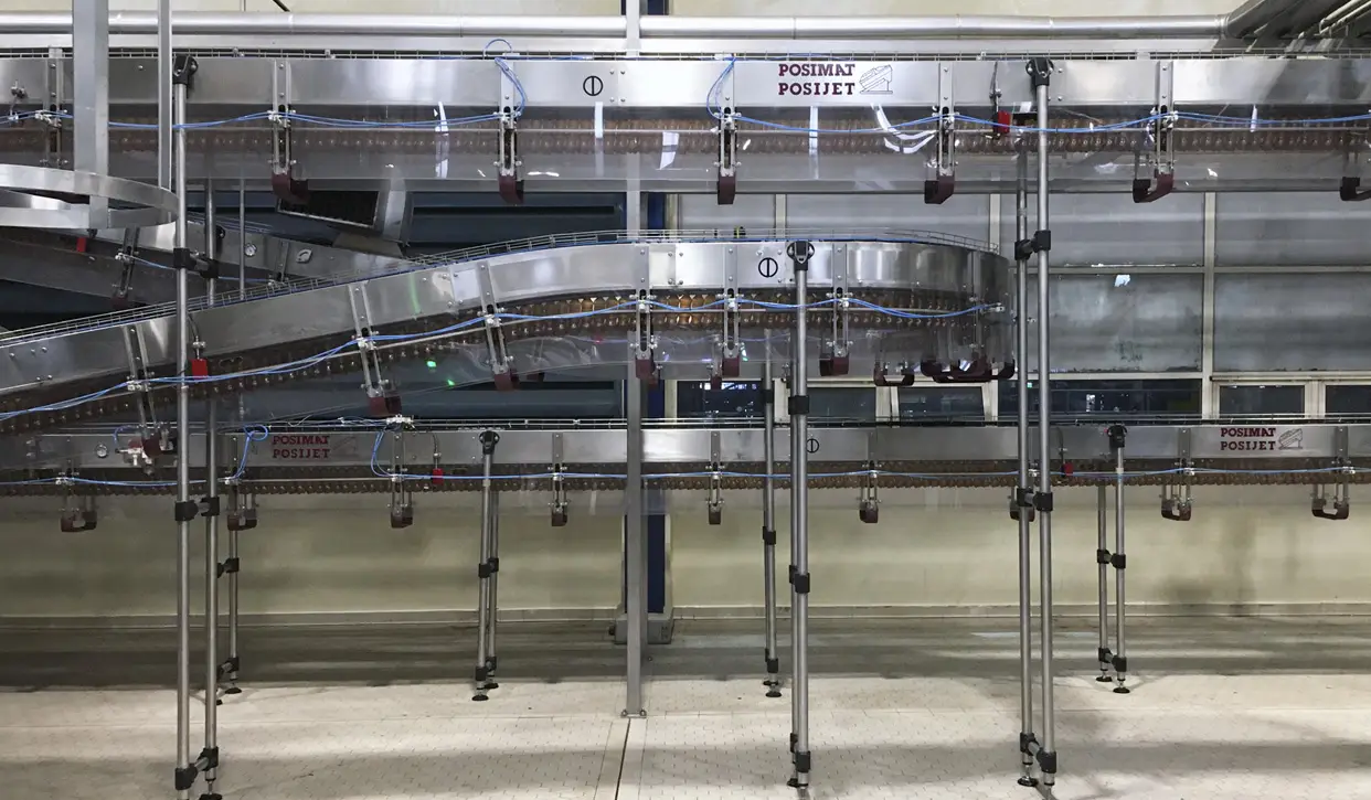 POSIMAT POSIJET air conveyor installation connecting multiple packaging lines with efficient overhead bottle transport.