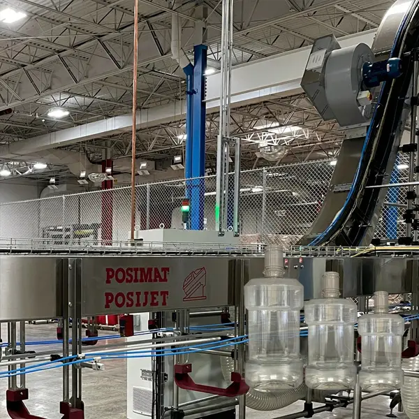 POSIMAT POSIJET air conveyor system transporting PET bottles in a high-speed mouthwash bottling plant, improving efficiency and reducing production bottlenecks.